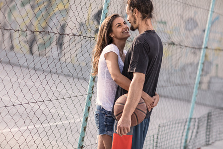 beautiful couple playing basketball and flirting at the basketball courtの写真素材