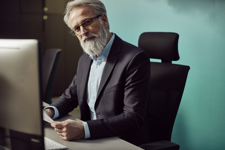 handsome caucasian senior CEO working late hours.の写真素材