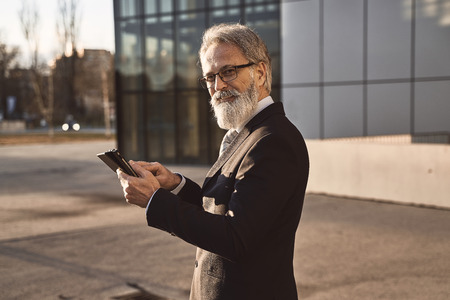 caucasian senior CEO using a smartphone and smart tabletの写真素材