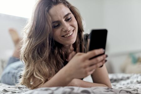 cute caucasian female using her smart phoneの写真素材