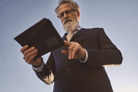 businessman using modern technology in front of a business buildingの写真素材