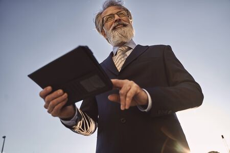 businessman using modern technology in front of a business buildingの写真素材