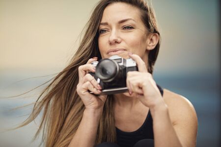portrait of a beautiful brunette photographer taking pictures on her holidays.の写真素材