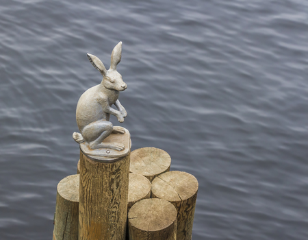 Statuette of a hare on a logの写真素材