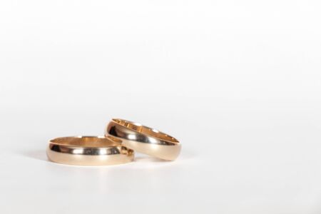 Two gold wedding rings close up on a white backgroundの写真素材