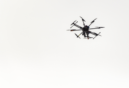 Multicopter floating in the air against a gray sky
