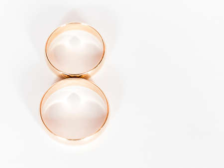 Two gold wedding rings close up on a white backgroundの写真素材