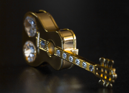 Golden board figure guitar on a black backgroundの写真素材