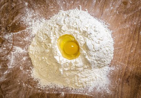 Raw egg in flour on the kitchen table closeupの写真素材
