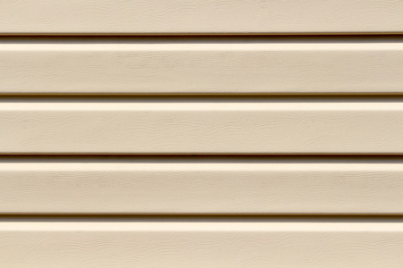 The surface of the beige plastic siding close up as a backgroundの写真素材