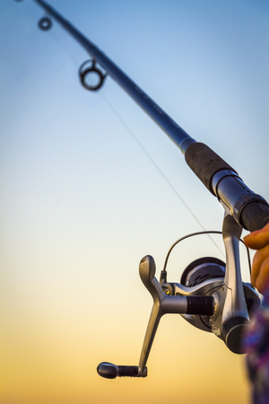 Fisherman fishing rod on the sunset close-upの写真素材
