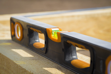 Tool measuring the level on a wooden truss construction closeup