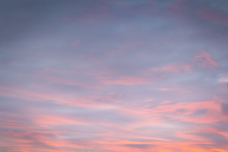Thick clouds are illuminated by the setting sun.