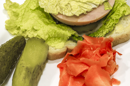 Sandwich with sausage and cabbage closeup on a white table.の写真素材
