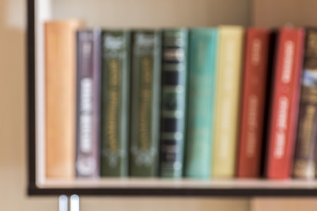 Books on a shelf out of focus as a background.