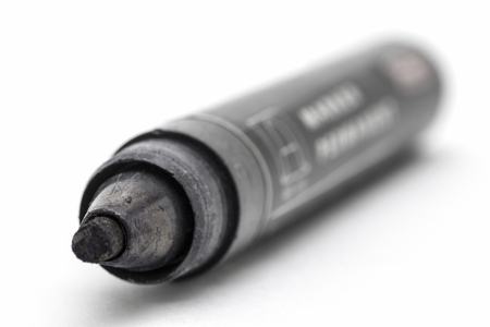 Thick black marker closeup on a white background.の写真素材