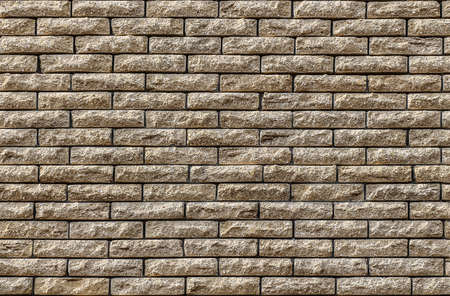 Wall made of decorative yellow brick as a texture and background.