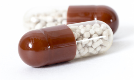 Brown medical pills close up on white background.の写真素材