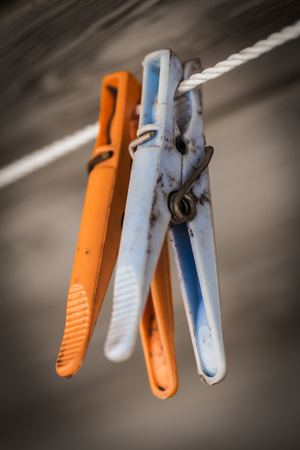 Plastic colored clothespins on a rope close-up.の写真素材