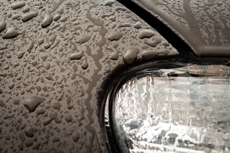 The front of the wet brown car close-up.の写真素材
