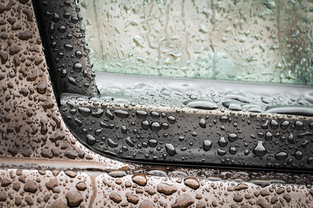 The part of the wet brown car close-up.