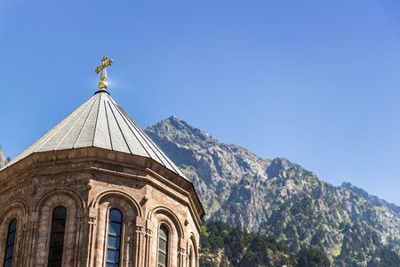 An old stone church on top of a mountain with a beautiful view.
