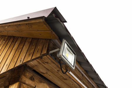 Garden LED spotlight on a wooden building close-up.