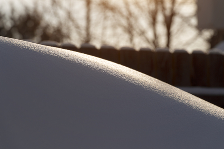 A large snowdrift in the backyard in the rays of dawn.の写真素材