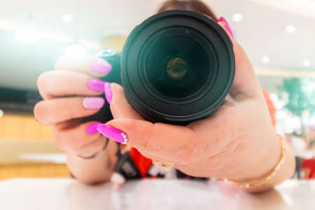 A female photographer is preparing to take a close-up photograph.の写真素材