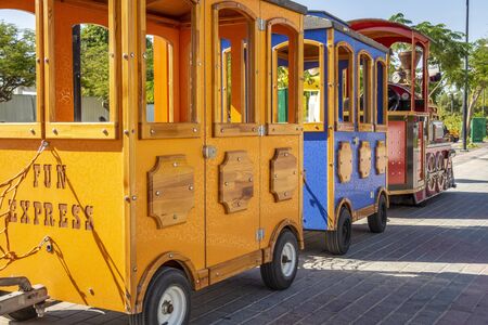 Children's colorful train awaits departure in the amusement park.