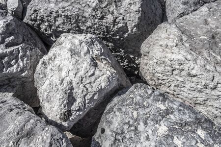 Huge gray boulders lie on the beach.