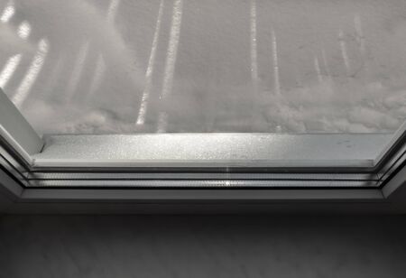 White snow lies on a windowsill close-up.の写真素材