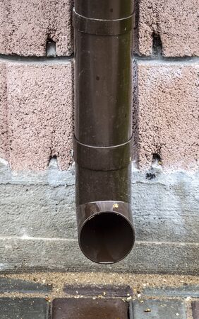 Brown drainpipe on the wall of a private house.