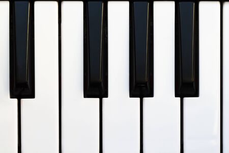 Black and white piano keys close up.の写真素材