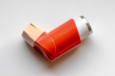 Asthma inhaler closeup on a white table.の写真素材