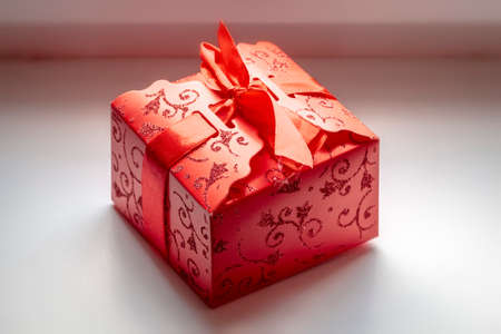 Gift in red packaging with a red ribbon close-up.