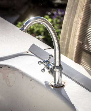 Old rusty garden chrome water tap closeup.