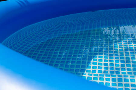Part of a blue inflatable pool in the backyard of a private house.