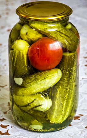 A glass jar with homemade canned cucumbers.の写真素材