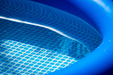 Part of a blue inflatable pool in the backyard of a private house.の写真素材