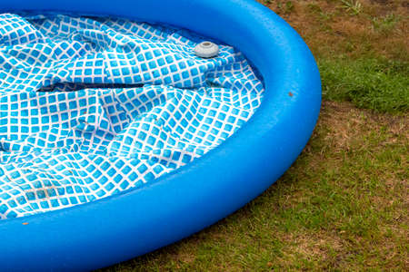 A deflated inflatable pool on the backyard lawn.の写真素材