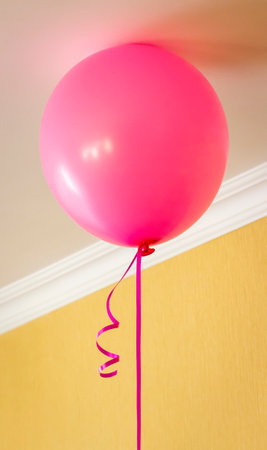 Balloons filled with helium hang from the ceiling of the room.の写真素材