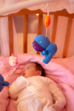 Musical baby rotating toy hangs above the crib.の写真素材