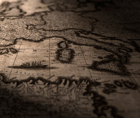 A fragment of an old map of Europe is illuminated by a table lamp.の写真素材