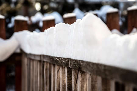 Rural wooden fence covered with freshly fallen snow.の写真素材