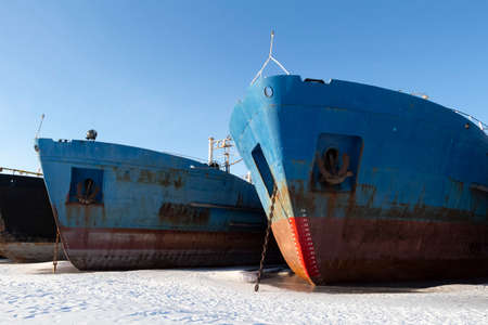 Cargo ships are in a shipyard frozen into the ice.の写真素材