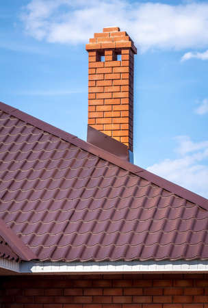 Brick pipe on the roof of a private house.の写真素材