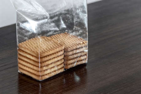 An open half-empty polyethylene pack of cookies on the table.の写真素材