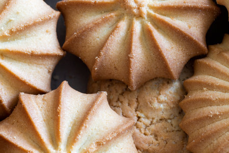 A plate with crumbly curly cookies close-up.