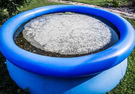Dirty stagnant water in an abandoned inflatable pool.の写真素材